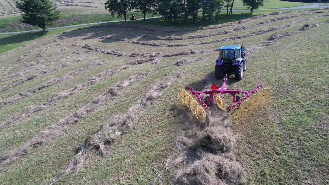 rastrillo de heno tirado por un tractor en el campo durante el tiempo de cosecha cerca de boone nc, carolina del norte