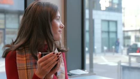 pretty brunette enjoying coffee in cafe