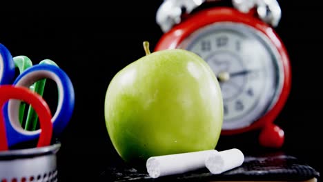 close-up of green apple with school supplies