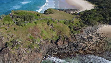 bird's eye view of the tourists climbing up the coastal walk of norries headland in nsw, australia