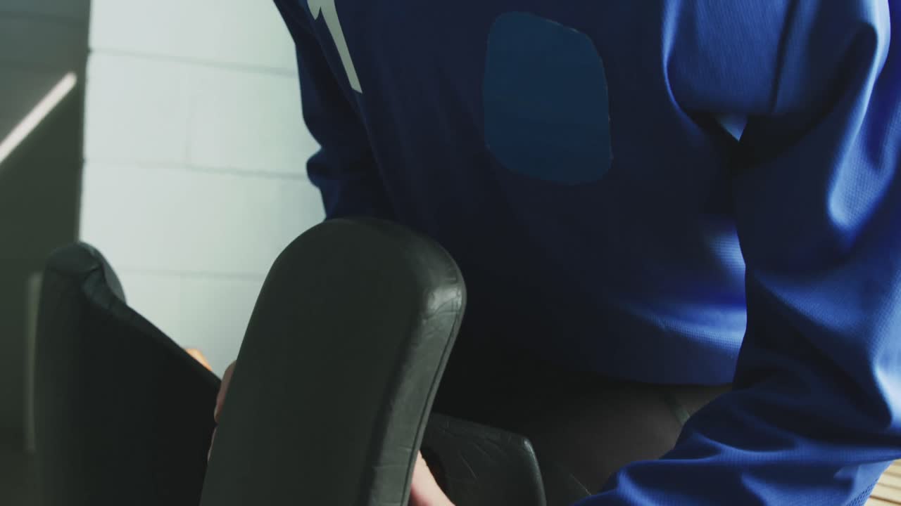 jugadora atando su equipo en el vestuario