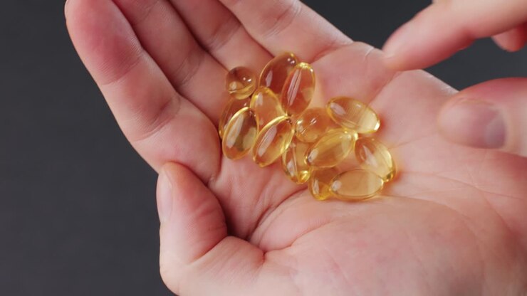 Omega fish oil gel capsules on man hand close-up . Human keeps in hands Omega vitamins pills 3 6 9. To be healthy and take care of your health. Pharmaceutical industry. Business of biological supplements and vitamin.