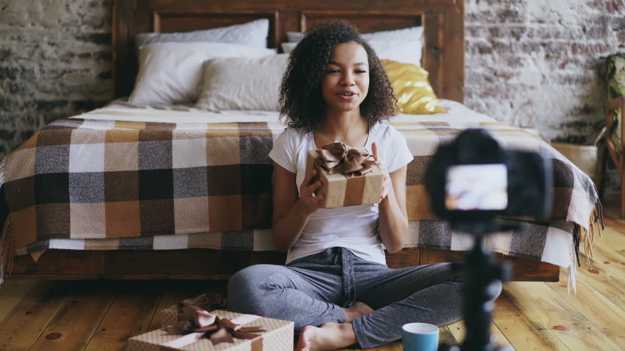 Young Woman Unboxing Gifts in Cozy Bedroom