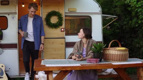 portrait of cheerful couple outdoors near their trailer house