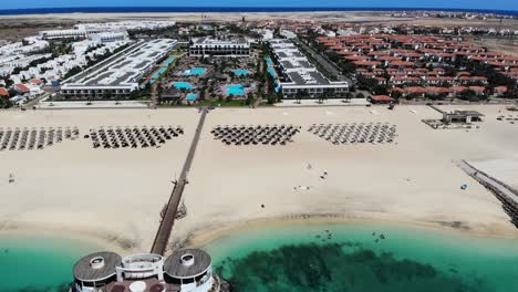sombrillas de playa bikini con villas y piscinas en segundo plano.