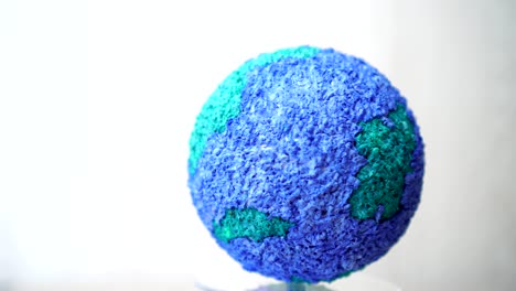 la creación de modelos giratorios de papel artesanía globo terrestre, girando el mundo ecología global en fondo gris. bucle creado en 4k