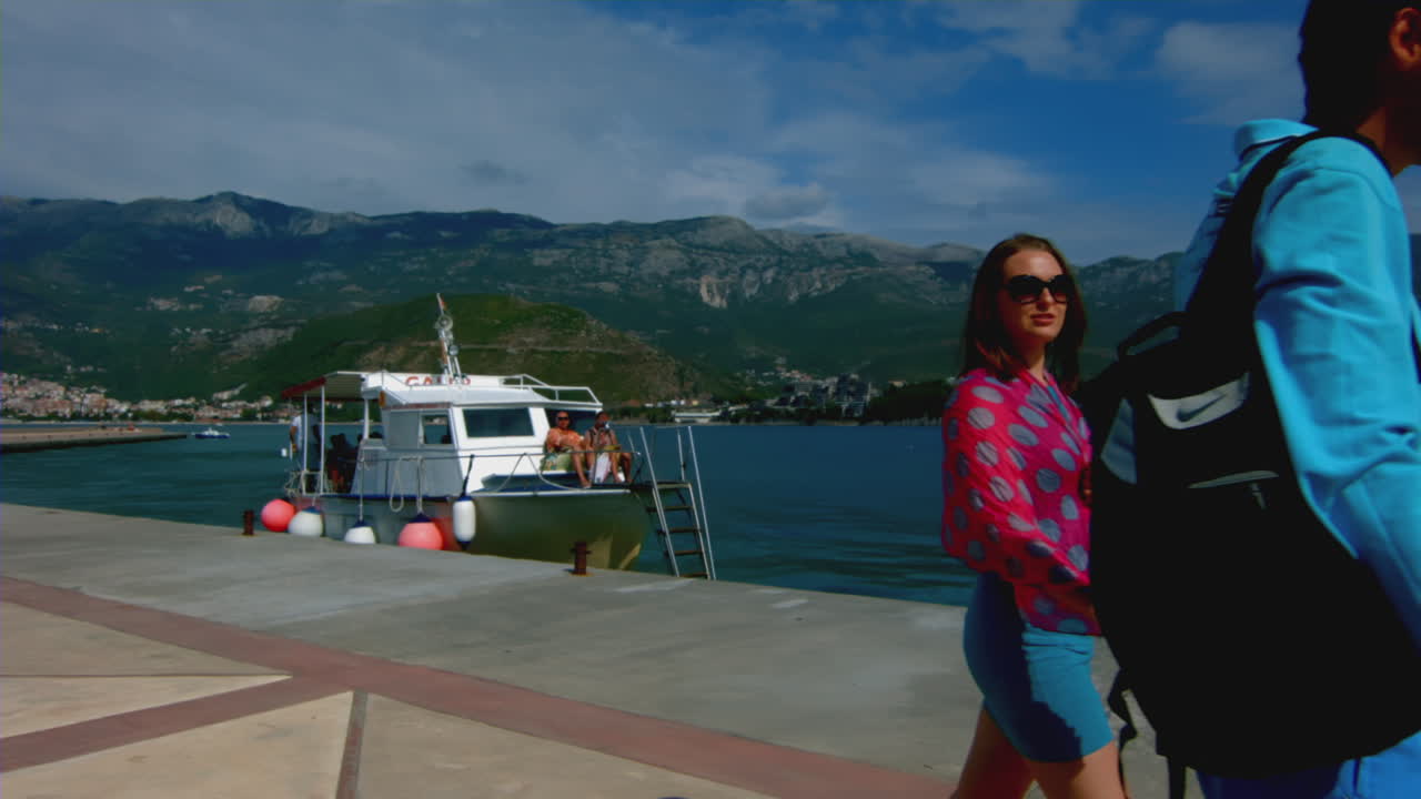 personas saludando desde un barco atracado en un muelle