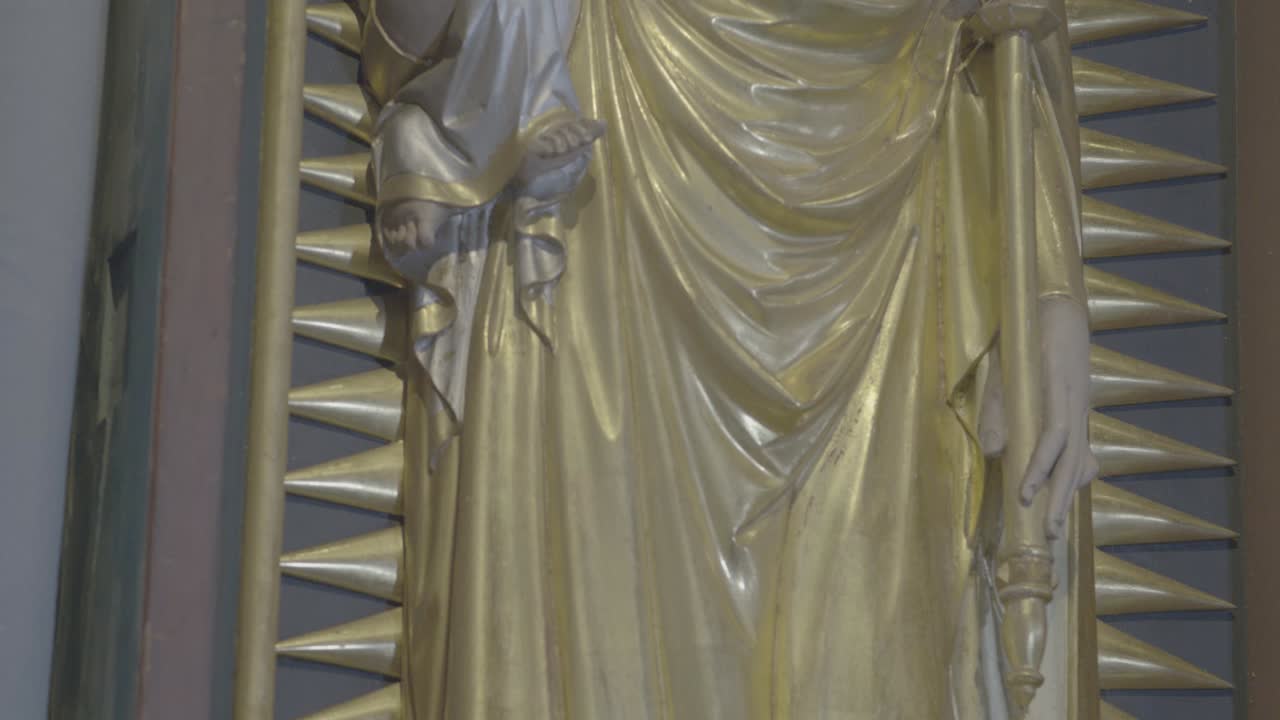 Camera movement along a relief of Mary with Jesus on her arm