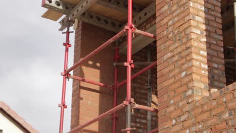 tiro inclinado del nuevo sitio de construcción de la casa que muestra andamios en el segundo piso y el techo