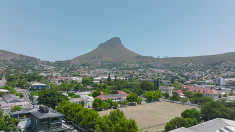 Forwards-fly-above-residential-urban-neighbourhood,-Lions-Head-Mountain-in-background.-Cape-Town,-South-Africa