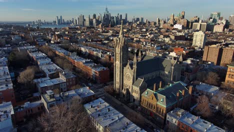 Excelente-Antena-De-La-Iglesia-Católica-De-St-Agnes-Brooklyn-Con-El-Horizonte-De-Manhattan-En-Segundo-Plano