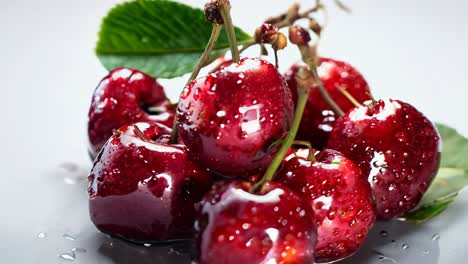 freshly picked cherries with droplets arranged on a white surface