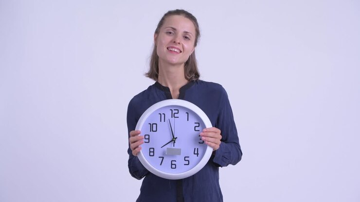 Happy young beautiful businesswoman with wall clock