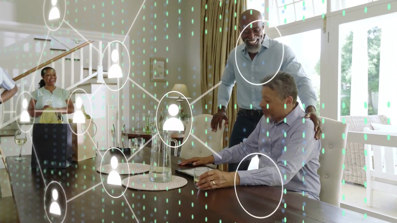 Seated man being handed tablet and tapping to explore tech network, overlay appearing around group