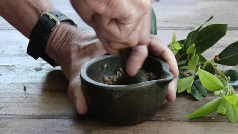 Grinding-spices-using-a-brass-mortar-and-pestle,-close-up