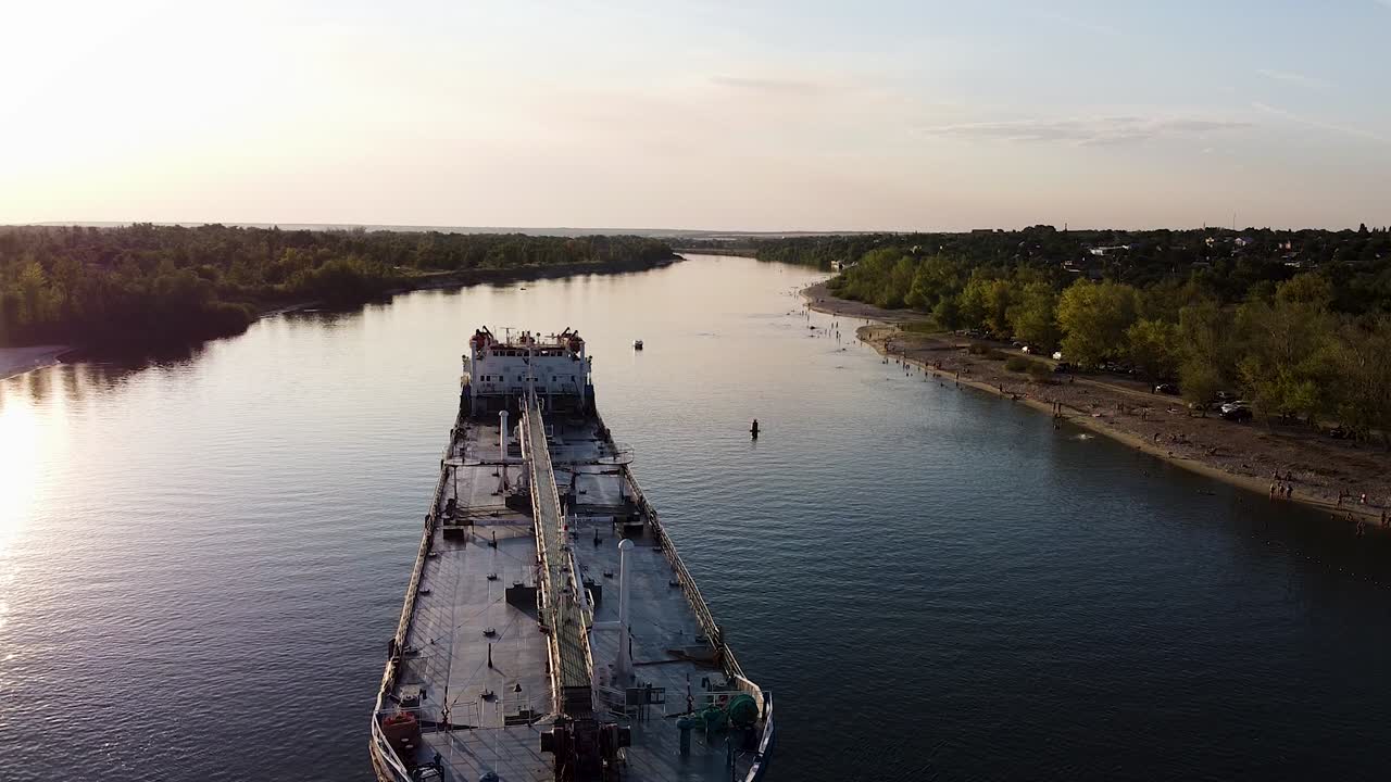 크에 있는 사람들과 함께 해가 지는 강에서 석유 커