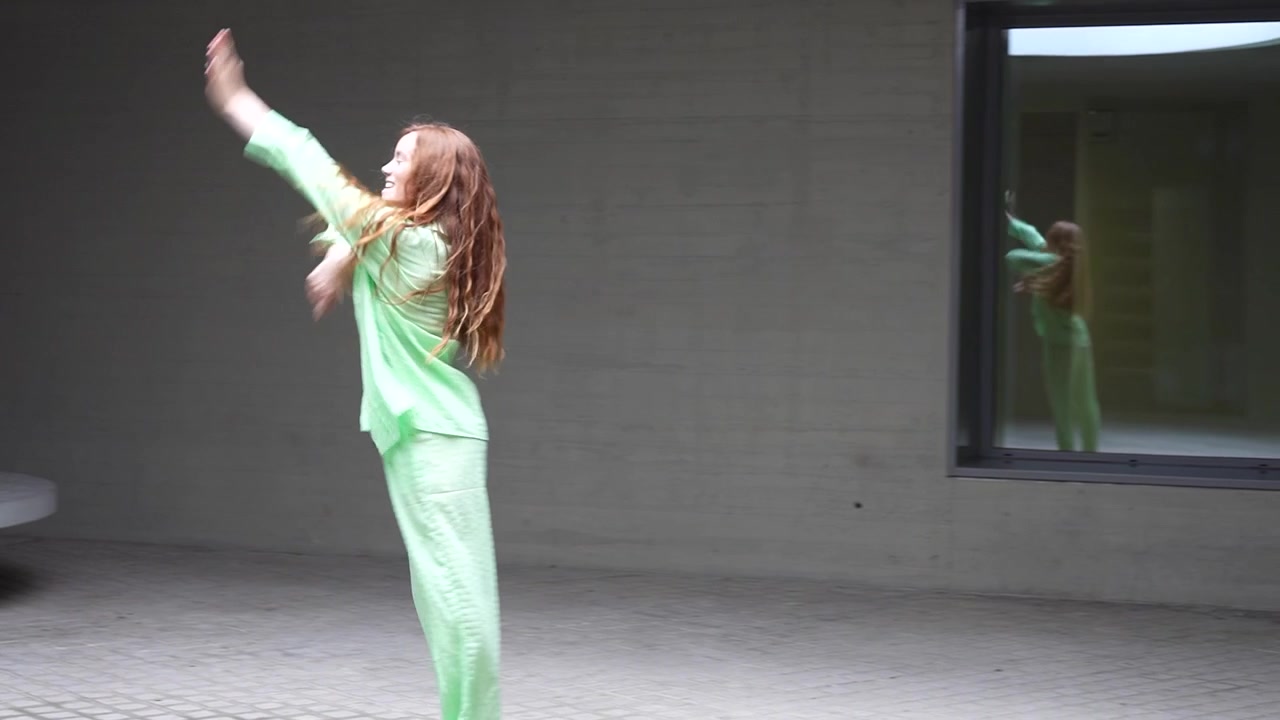 Dynamic dance movements in vibrant green attire with expressive choreography and energetic motion
