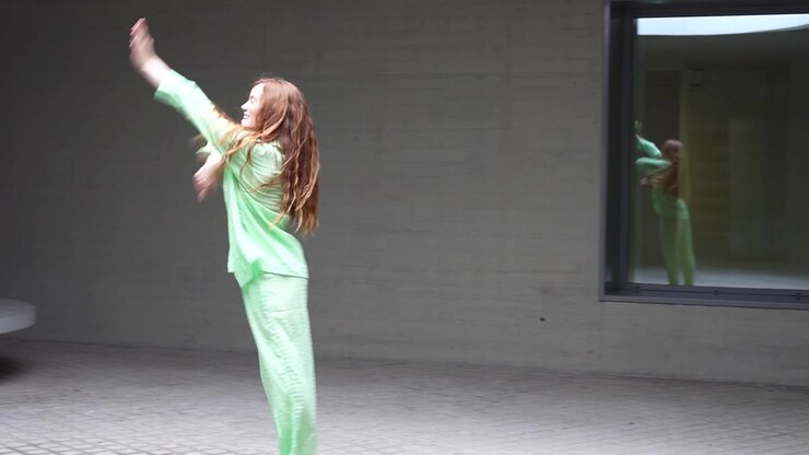 Dynamic dance movements in vibrant green attire with expressive choreography and energetic motion