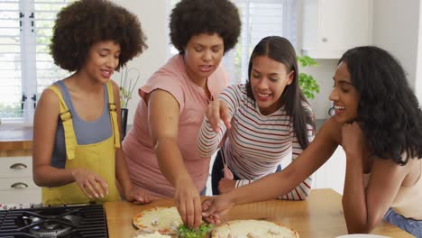 Happy-diverse-female-friends-talking-and-cooking-together-in-kitchen