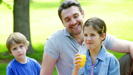 Padre-E-Hijos-Relajándose-Juntos-En-El-Parque