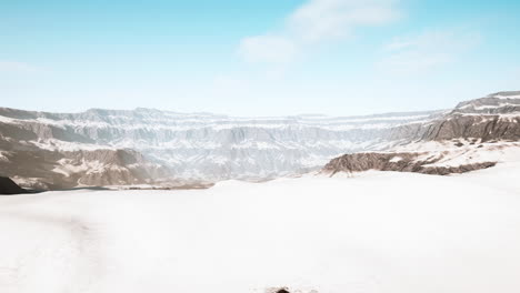 snowy mountains with deep ravine and rock cliffs