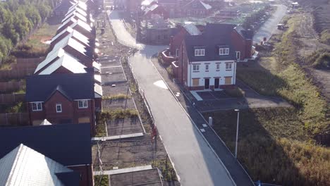 Aerial-view-morning-sunrise-over-British-suburban-town-housing-development-building-site