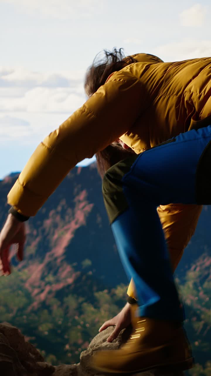 Persona che si arrampica su una cresta rocciosa di montagna con vista panoramica
