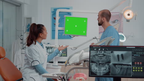 dentist and assistant looking at green screen on monitor