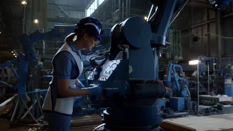 factory worker interacting with a robotic arm