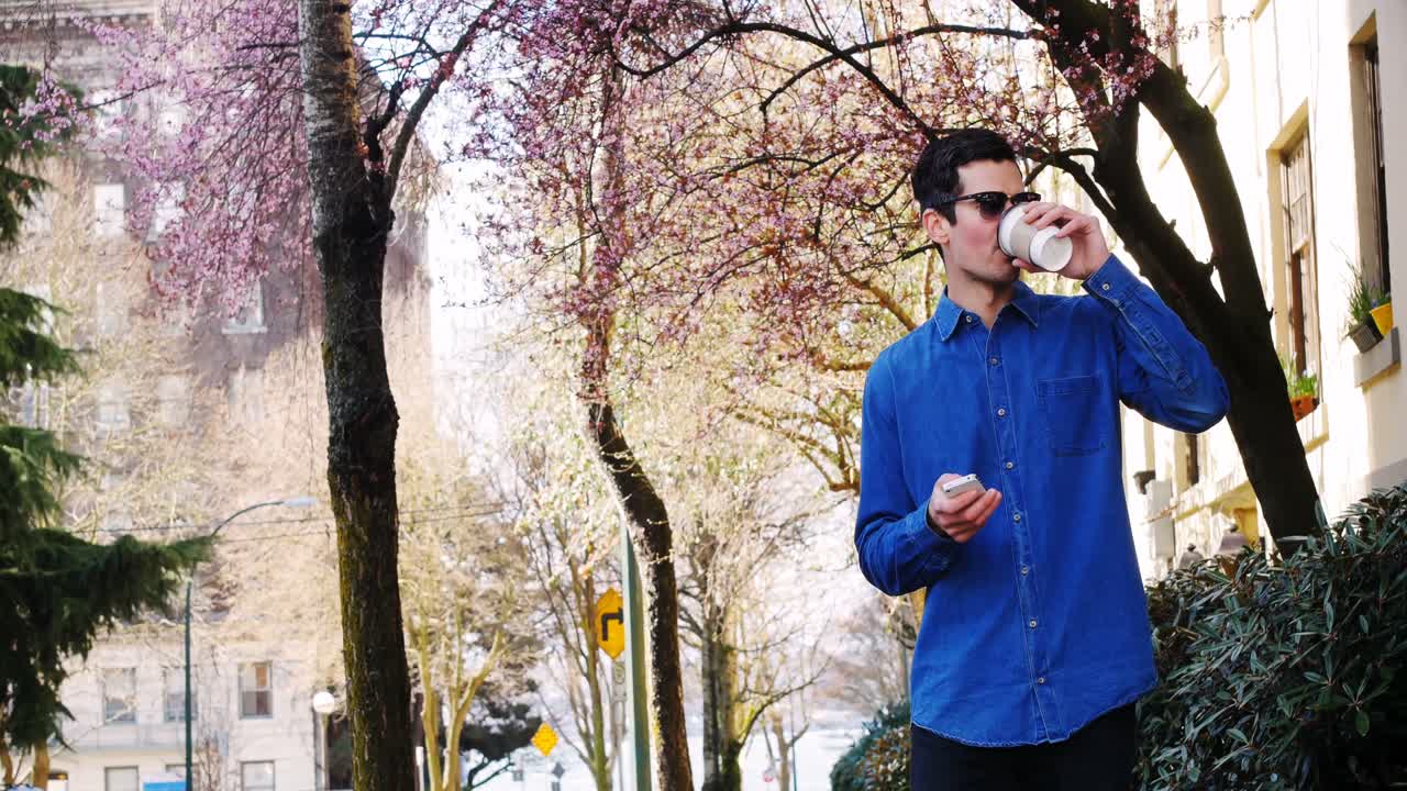 공원 4k에서 커피를 마시면서 휴대폰을 사용하는 남자