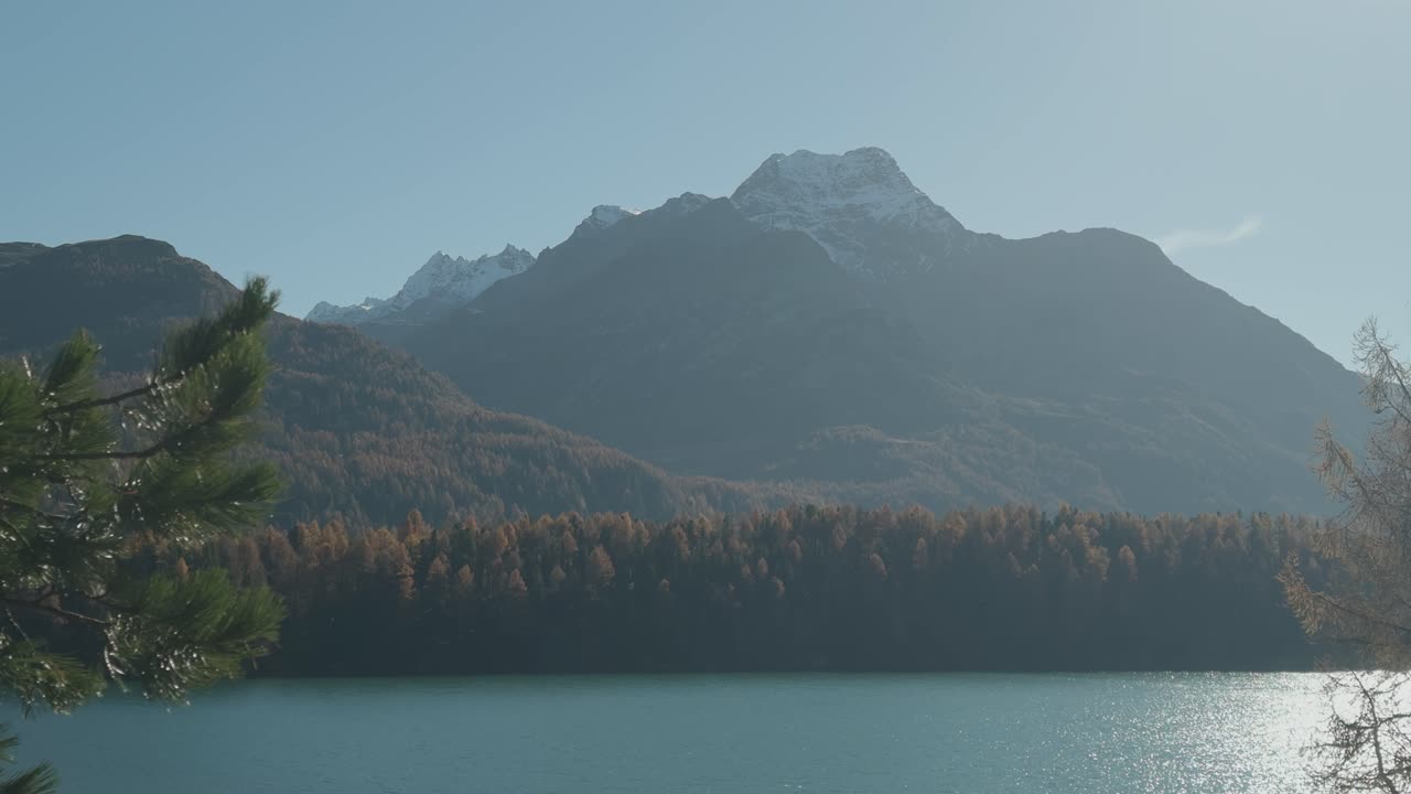 big mountain by the lake in the autumn landscape. big colorful autumn forest and snow on the mountain