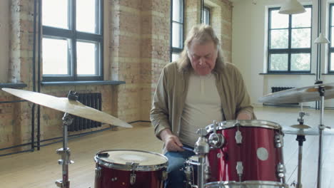 old drummer playing drums in studio