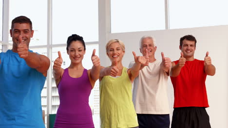 clase de fitness mostrando los pulgares hacia arriba