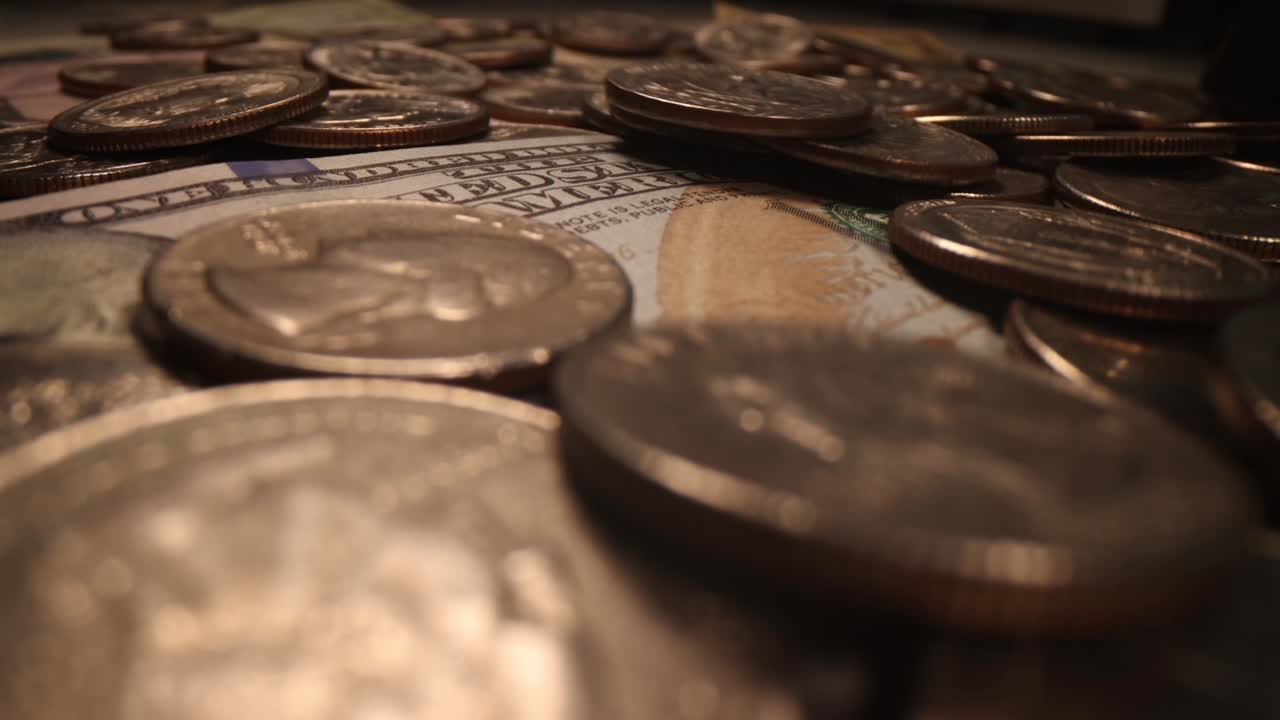 billetes estadounidenses y monedas que caen en fondo oscuro