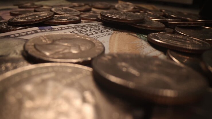 American banknotes and falling coins in dark background