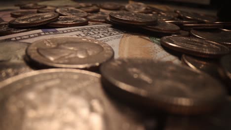 billetes estadounidenses y monedas que caen en fondo oscuro