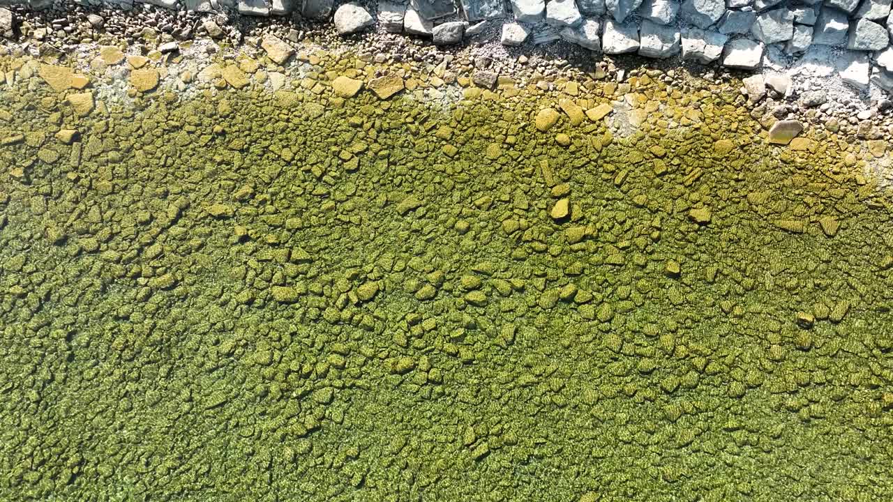 Direct aerial over the greenish clear water in Petoskey Bay