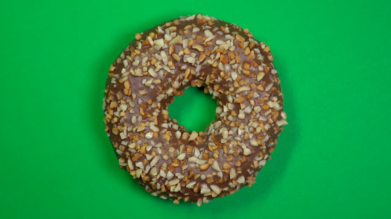 delicioso y fresco rosquilla de rosquilla macro disparo de primer plano girando sobre un fondo verde.