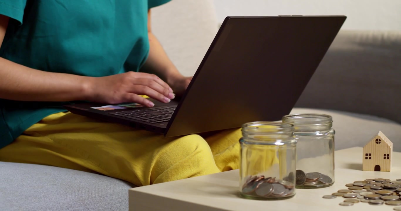 Uma pessoa gerencia finanças em um laptop em um ambiente doméstico aconchegante, refletindo a tendência do trabalho remoto.