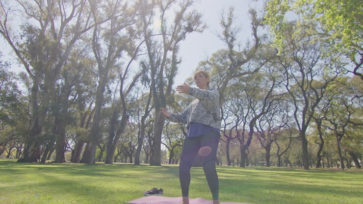 Kvinde dyrker Tai Chi i en park
