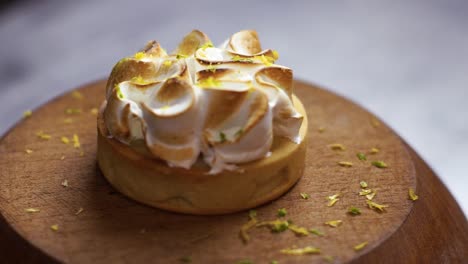 lemon pie meringue toasted on wooden board on kitchen rag