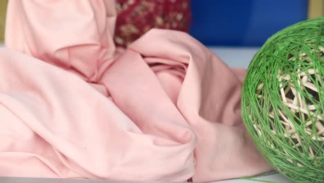 pink fabric and green yarn ball
