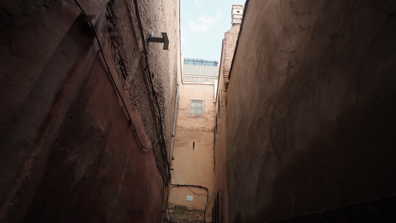 Alte mura e stretto vicolo di pietra che conducono all'arco all'interno della Medina di Marrakech