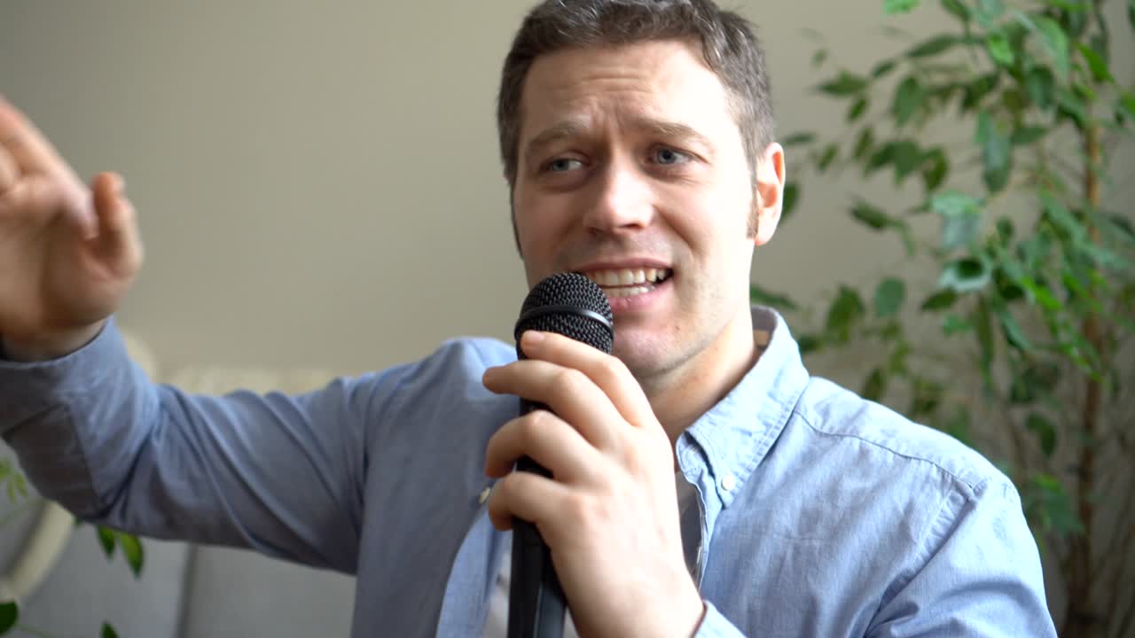 Mand synger karaoke derhjemme. Nærbillede