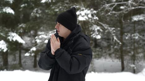 medium shot of a white male isolated and cold in a snowy winter forest