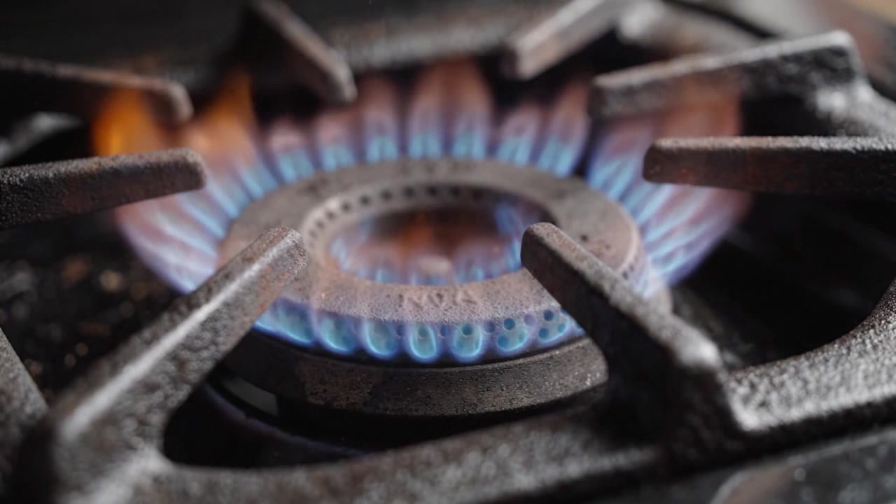 A Close-Up View of a Gas Burner Igniting and Producing a Vibrant Flame in a Kitchen Setting, Showcasing the Intricacies of Cooking Equipment