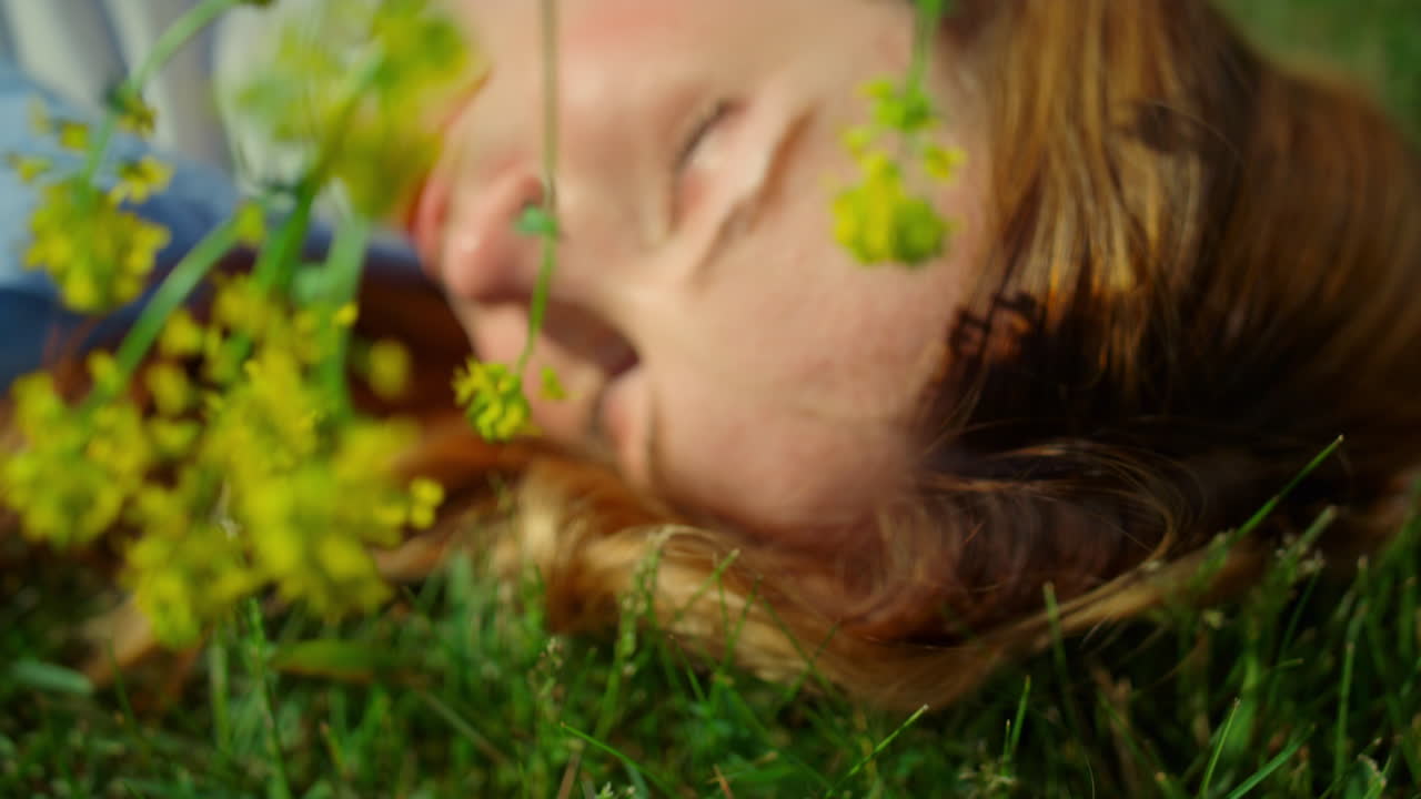 retrato de una mujer irreconocible con flores silvestres disfrutando del sol con los ojos cerrados.
