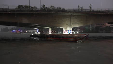 empty long tail boat in the chao phraya river during a thunderstorm in bangkok thailand