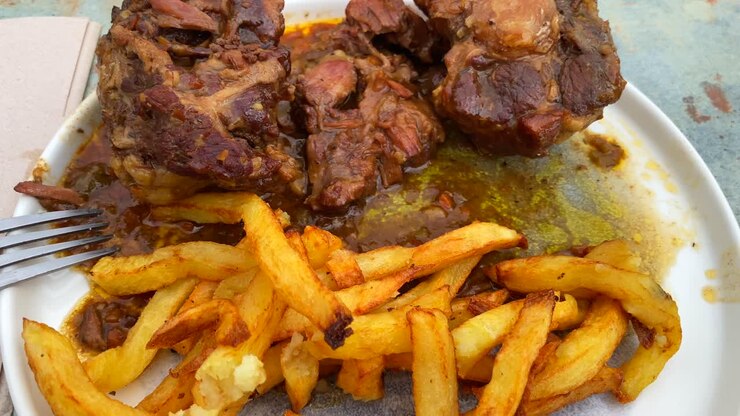 Coda di bue alla spagnola tradizionale con patatine fritte, carne cotta lentamente in salsa di vino rosso nella zona di Malaga, Spagna, ripresa 4K.