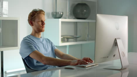 it worker typing desktop computer in home office closeup. remote workplace view